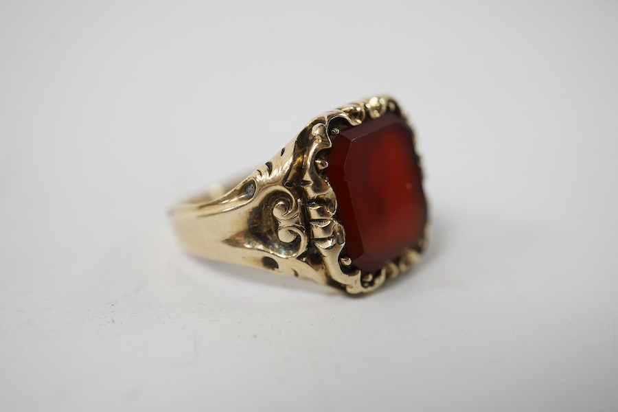 A carved yellow metal and carnelian set signet ring, size I/J, gross weight 5.1 grams. Condition - fair